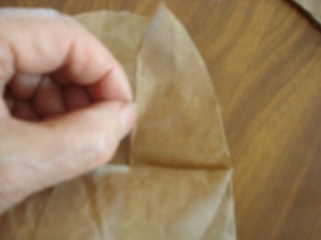 Fold the little rounded triangles from the semicircle down once and up again, to make ears.