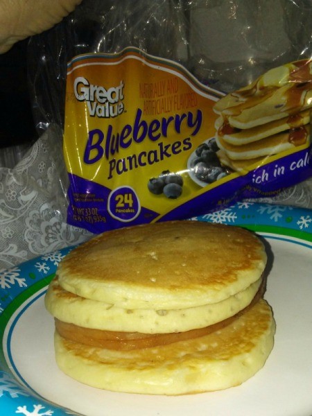 A breakfast sandwich with ham and pancakes.