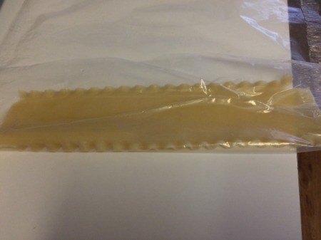 Rolling noodles in wax paper.