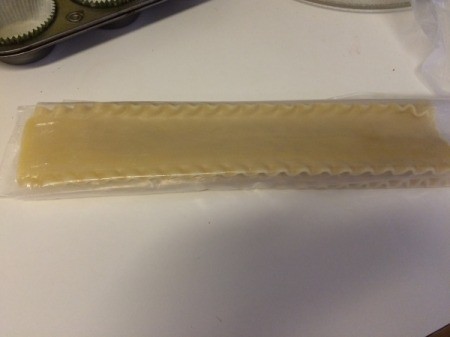 Rolling noodles in wax paper.