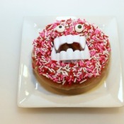 A sprinkled donut with vampire fangs.