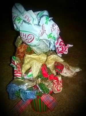 A tabletop Christmas tree decorated with ribbon.