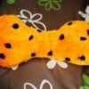 An orange and black bone shaped dog toy with a squeaker inside.
