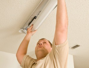 A man fixing a fluorescent light.