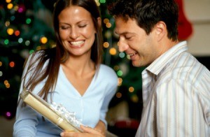 A girl giving a gift to her boyfriend.