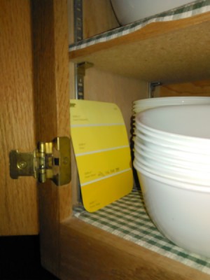A yellow paint sample being stored in the kitchen.