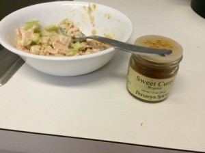 A dish of chicken salad with curry next to it.