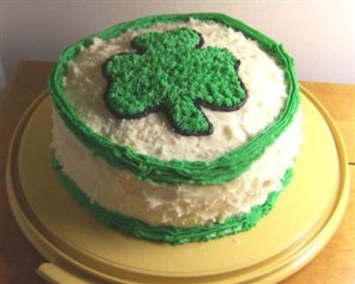 A layer cake with a shamrock in frosting on the top.