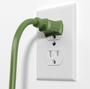 Electrical outlet with a green cord plugged in.