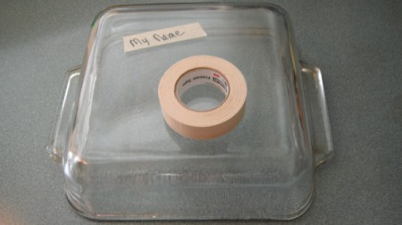 A name written on tape on the back of a casserole pan.