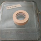 A name written on tape on the back of a casserole pan.