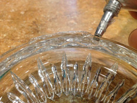 Thriftstore Glass Garden Tower - closeup of adding glue to piece number 2