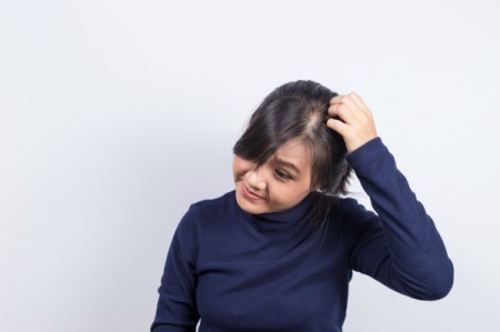 A woman scratching her head.