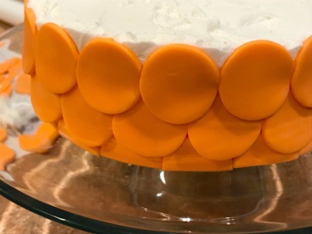 'Sharky' Goldfish Birthday Cake - continue adding orange circles to bottom layer of iced cake