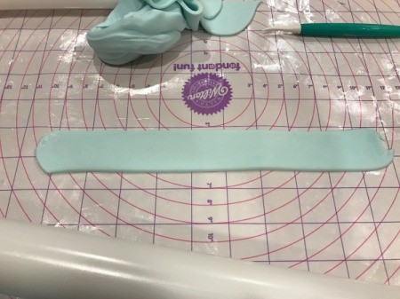 'Sharky' Goldfish Birthday Cake - thinly roll out the light blue fondant and cut into 1 inch stripes, continue with medium and darker blue fondant