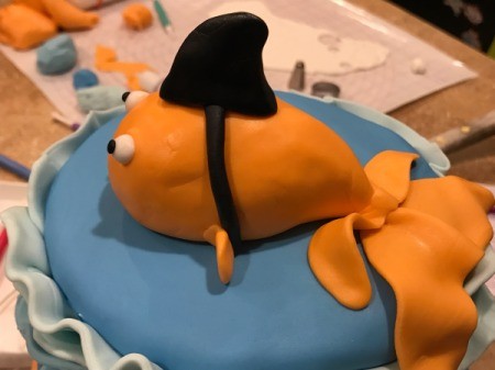 'Sharky' Goldfish Birthday Cake - Make the shark fin and strap out of black fondant and place them onto the goldfish's back.
