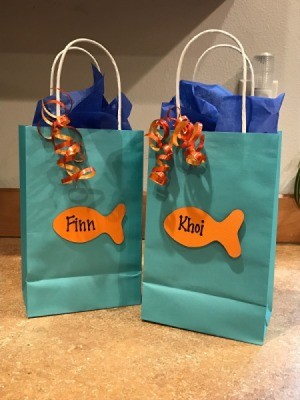 Goldfish Party Treat Bags - aqua gift bags with orange goldfish cutouts and ribbon as decorations