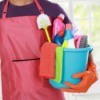 Man in an apron with a bucket of cleaning supplies.
