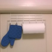 An over the door hook with paper towels and hotpads.