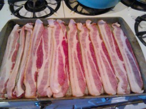 A pan of bacon on a cookie sheet, ready for the oven.