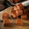 Fudge squares piled on a wooden pizza spatula.