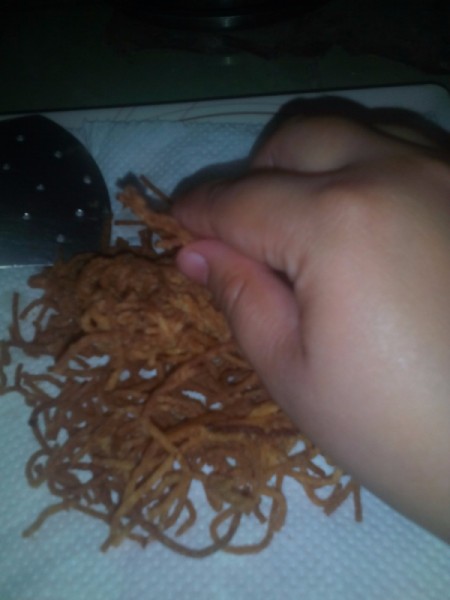 Breaking apart crunchy spaghetti noodles.