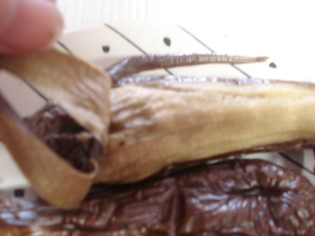 Peeling broiled eggplant.