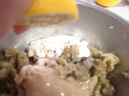 Adding yogurt and tahini to chopped eggplant.