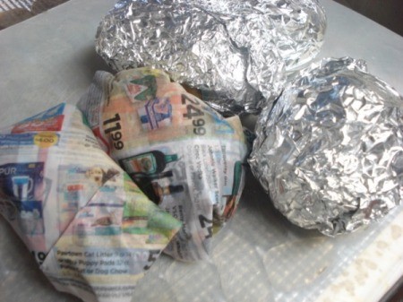 potatoes wrapped in foil and eggs wrapped in newspaper