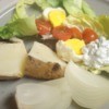 Plate with cooked potato, egg, dressing and lettuce