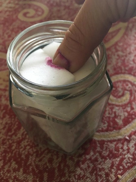 DIY Nail Polish Remover Jar - dipping thumb into jar to remove polish with polish residue on sponge