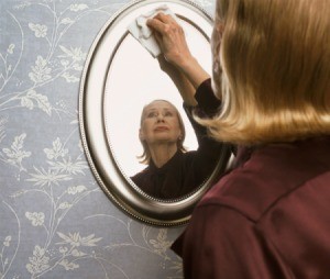 Cleaning a mirror with rubbing alcohol.