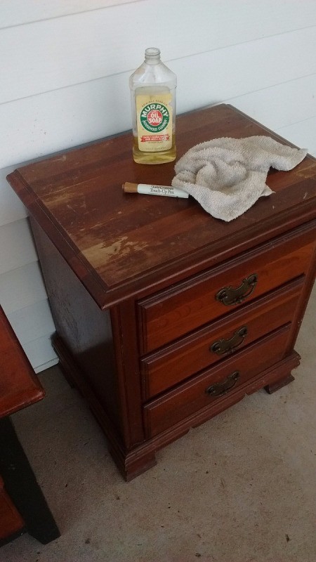 How to Fix Damaged Surfaces of Wood Furniture - small chest of drawers with bottle of oil soap, furniture pen, and rag on top