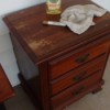 How to Fix Damaged Surfaces of Wood Furniture - small chest of drawers with bottle of oil soap, furniture pen, and rag on top