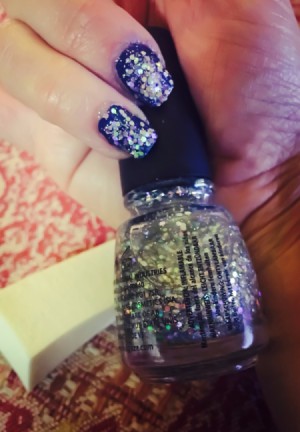 Glitter nails with the bottle of nail polish.