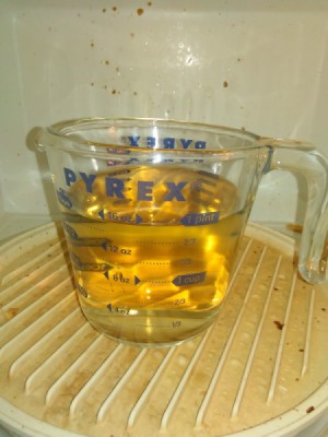Reuse Vinegar for Cleaning Jobs - cup of vinegar and water in the dirty microwave