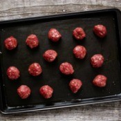 Tray of uncooked meatballs ready to be baked.