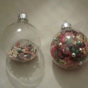 Two clear ornaments filled with beads.