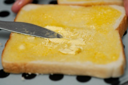 A piece of toast with melted butter.