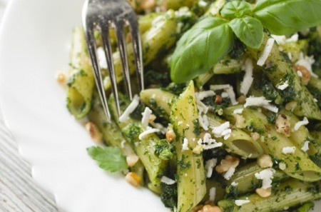 A plate of pesto penne with chicken.