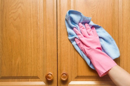 Cleaning a wood cabinet.