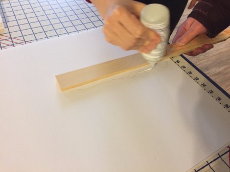 Gluing on the paint stirrer to the center back of the foam core.