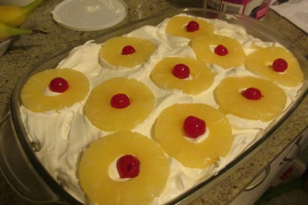 Pineapple with cherries on top of pan.