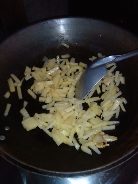 Cut potatoes in pan.