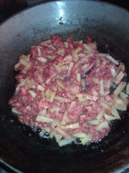 Corned beef and potato in pan.