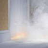 Smoke from a house fire coming from under a door.
