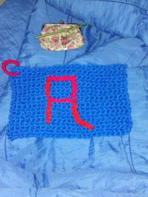 A crocheted dishrag with a letter "A".
