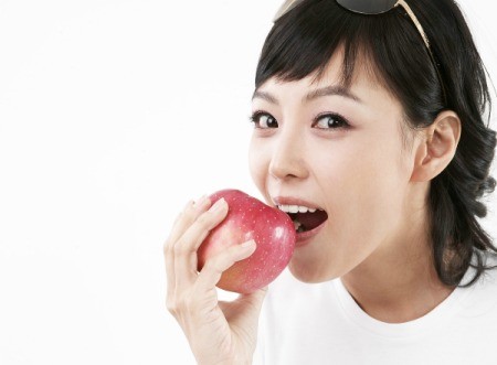 A woman eating an apple.