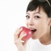 A woman eating an apple.