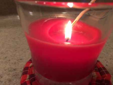 Lighting a candle with a long match.